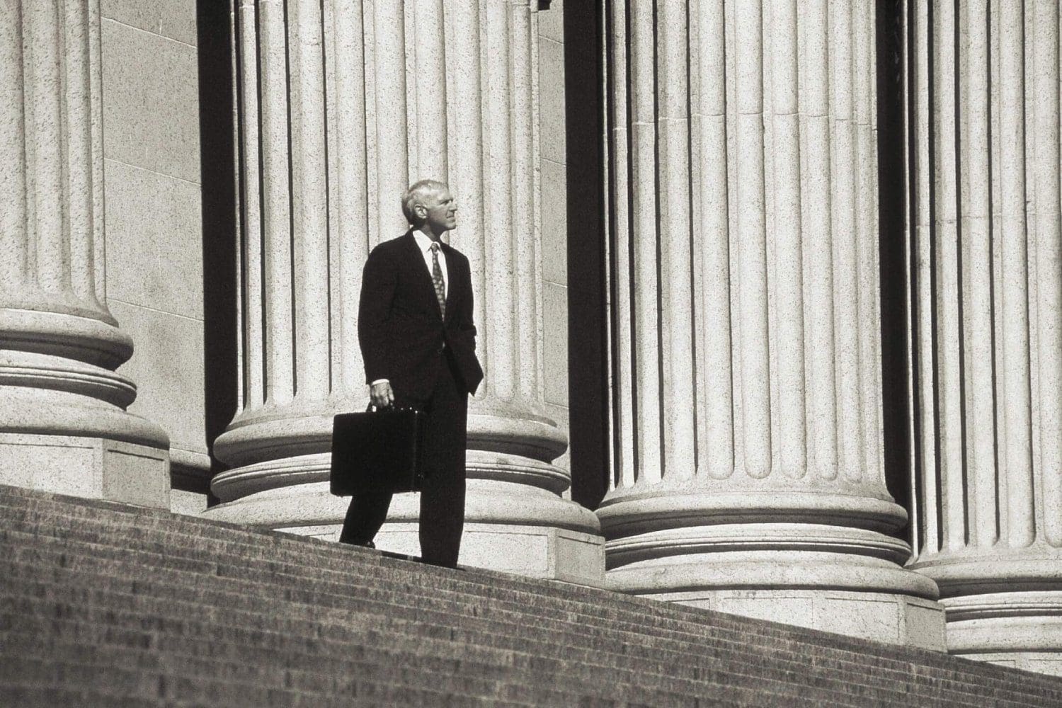 A man in suit and tie holding a briefcase.