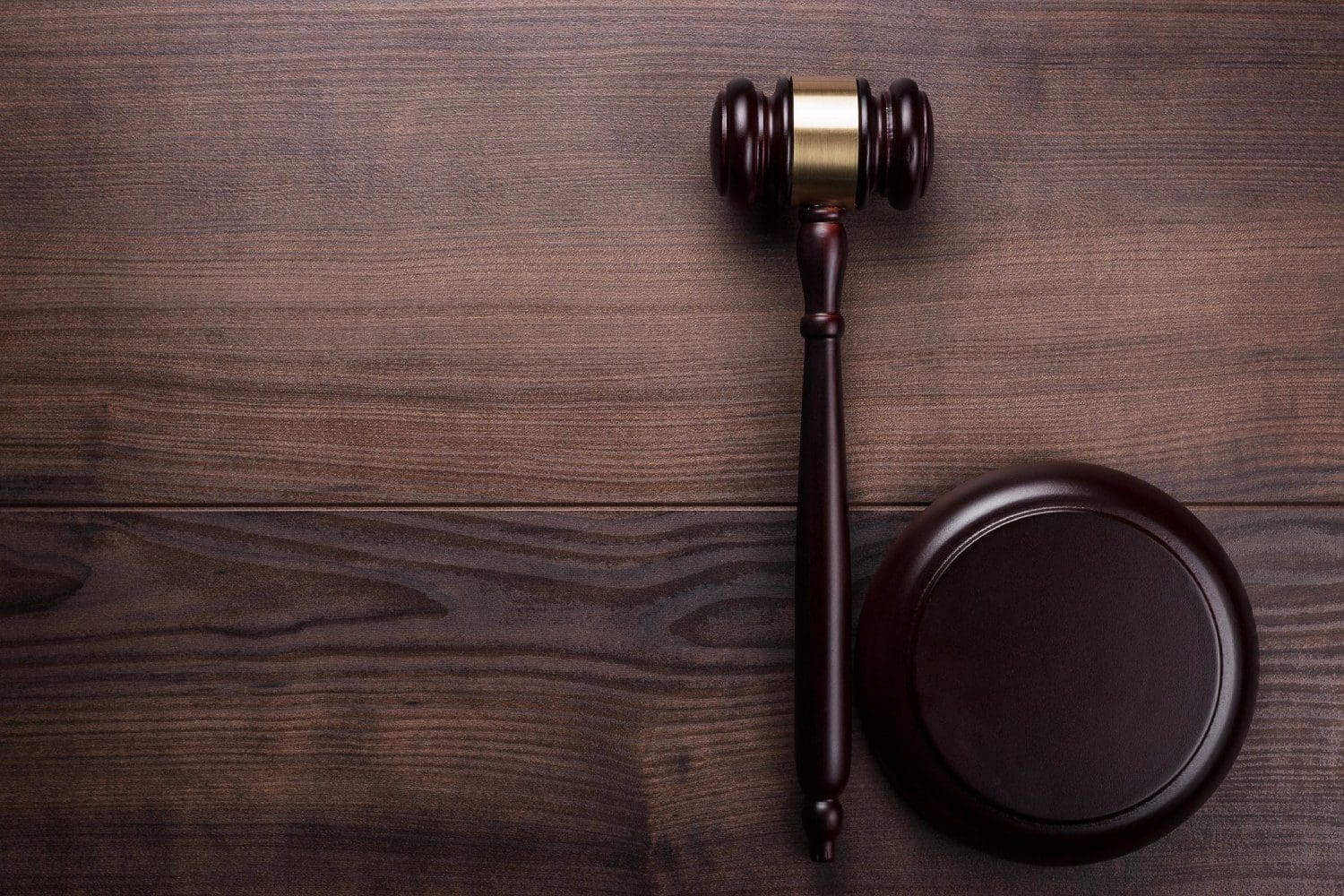 A wooden judge 's gavel and a brown table.