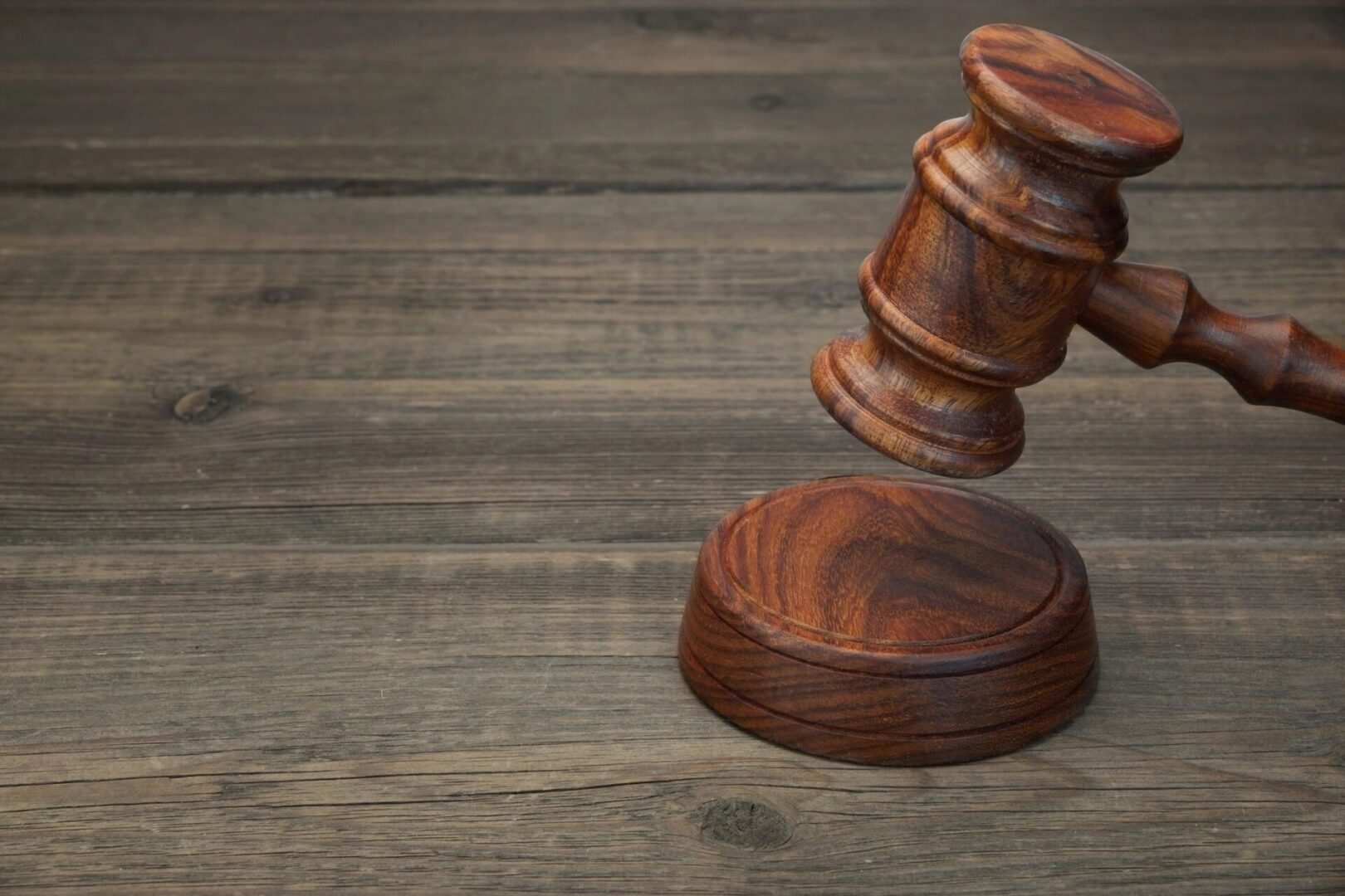 A wooden judge 's gavel on top of a table.