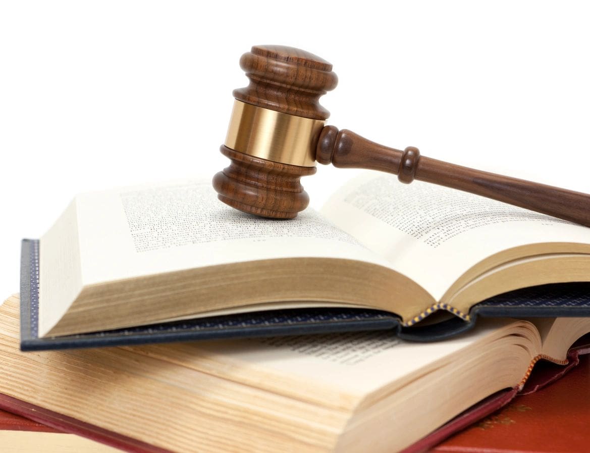 A wooden gavel sitting on top of an open book.