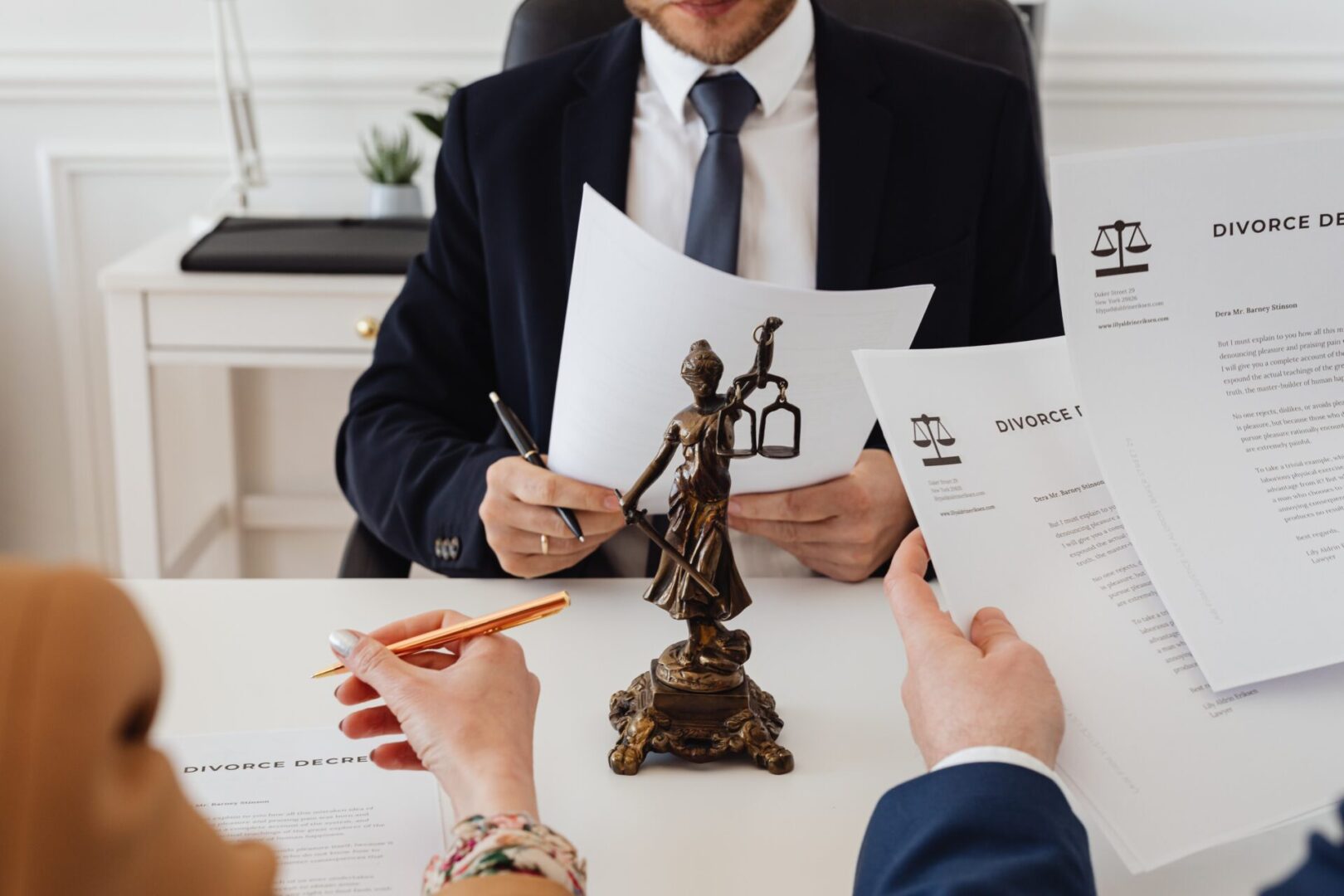 A man in suit and tie sitting at table with papers.