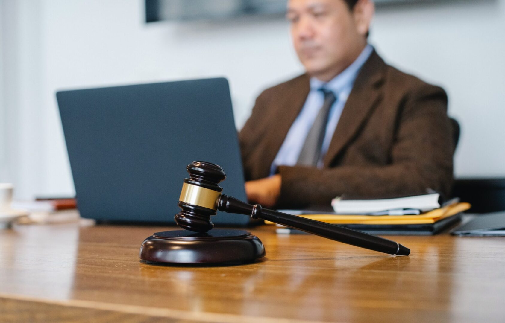 A judge 's gavel sitting on top of a wooden table.