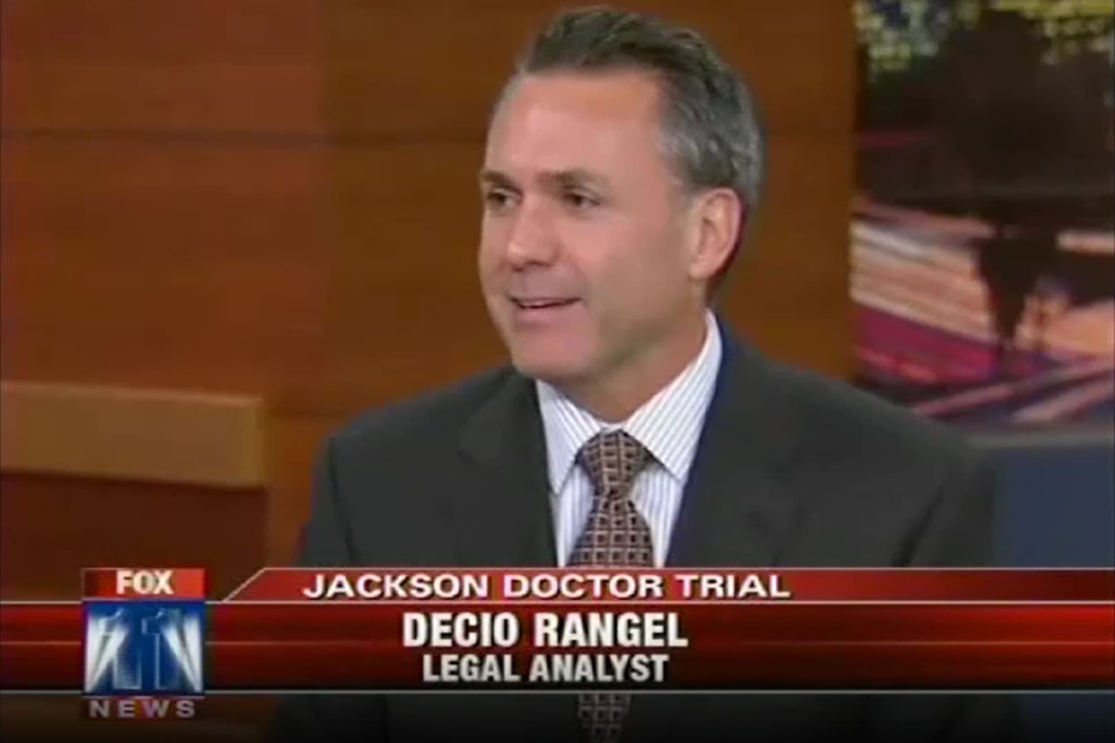 Law Offices of Decio Rangel, Jr. A man in suit and tie sitting on top of a desk.