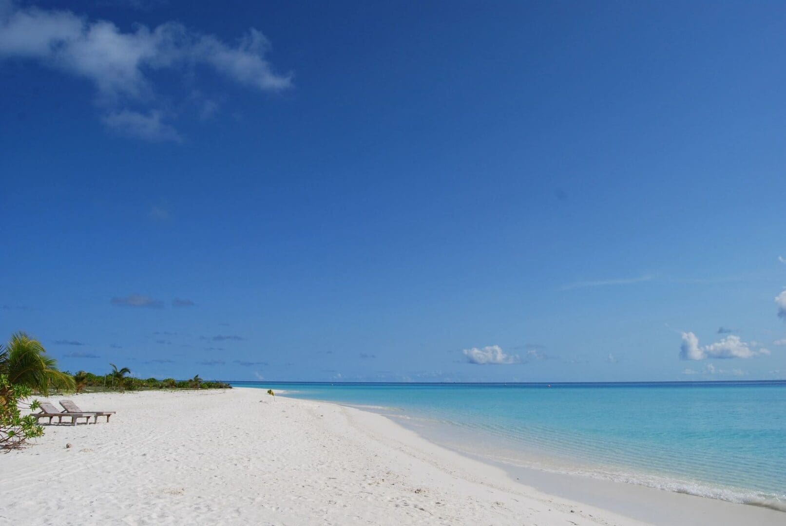 A beach with white sand and blue water.